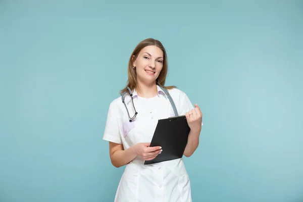 Красивая женщина-врач со стетоскопом и черной табличкой, на синем фоне. Скопировать пасту. Health concept. — стоковое фото