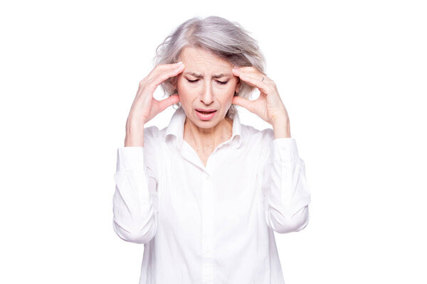 Портрет старой, но современной модной женщины, страдающей головной болью или мигренью, держащей голову в руках с отчаянным выражением лица и кричащей от боли, изолированной на белом фоне