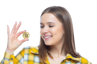 Beyaz arka planda izole edilmiş elinde bitcoin kripto para tutan sevimli bir kız resmi. Finansal okuma yazma, yenilik, başarı kavramı