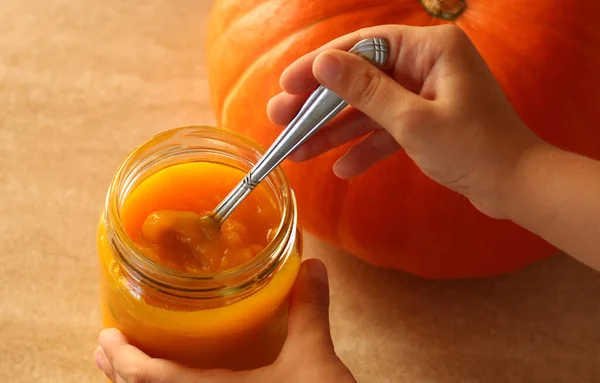 Kavanozda taze balkabağı püresi ve bej arka planda taze balkabağı.