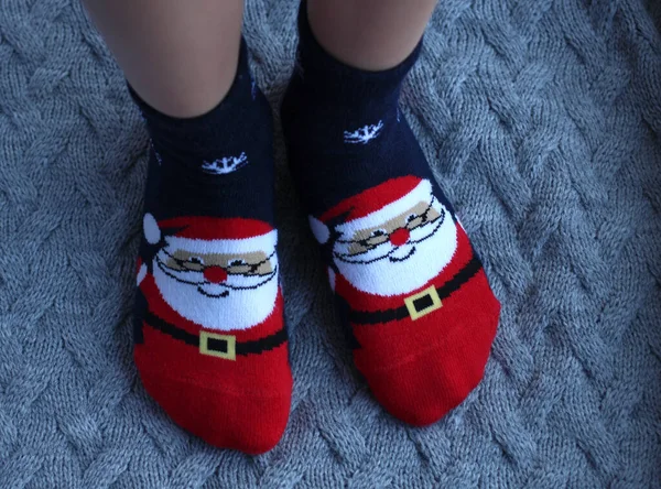 Dětské nohy v ponožkách se Santa Claus na šedém pozadí — Stock fotografie