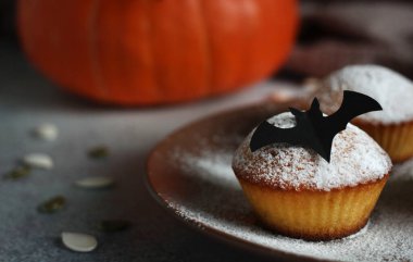 Balkabağı, kabak çekirdeği ve kara yarasayla pudralanmış kekler.