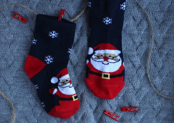 Festliche Kindersocken mit Weihnachtsmann-Klauseln auf grauem Hintergrund — Stockfoto