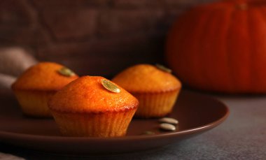 Kahverengi bir tabakta kabak ve kabak çekirdekli mini mafinler.