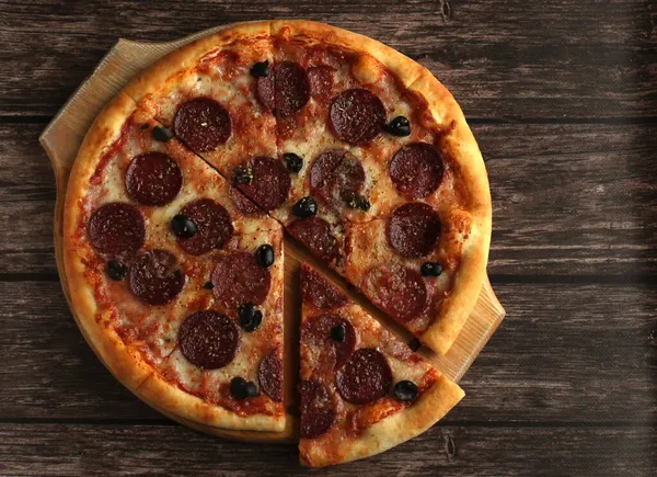 Pfefferoni-Pizza mit Wurst und Oliven auf dunklem Holzgrund — Stockfoto