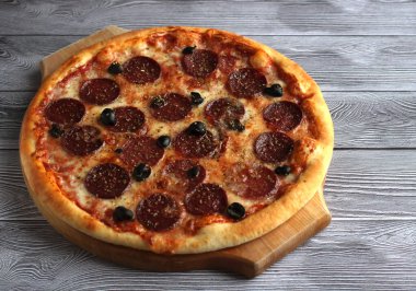 Gri arka planda tuzlu ve zeytinli biberli pizza