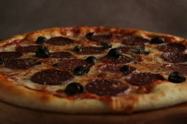 Pfefferoni-Pizza mit Wurst und Oliven auf dunklem Holzgrund — Stockfoto