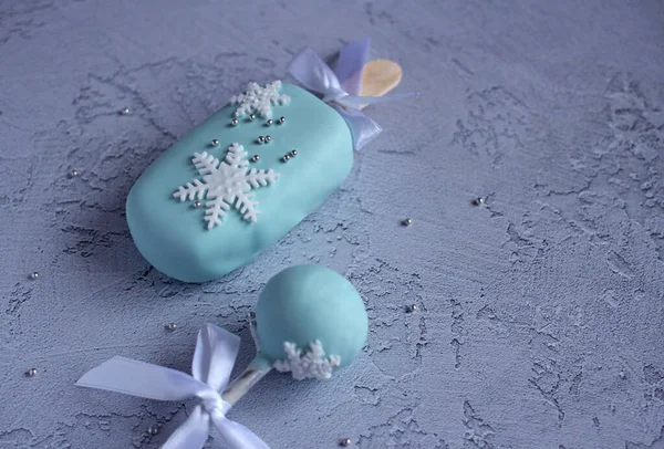 Nyår vackra kakor med snöflingor på en pinne på en blå bakgrund — Stockfoto