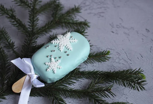 Año Nuevo hermosos pasteles con copos de nieve en un palo sobre un fondo azul —  Fotos de Stock