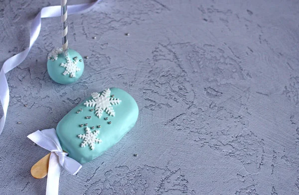 New Years beautiful cakes with snowflakes on a stick on a blue background — 图库照片