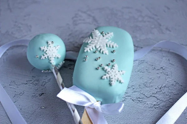 Nyår vackra kakor med snöflingor på en pinne på en blå bakgrund — Stockfoto