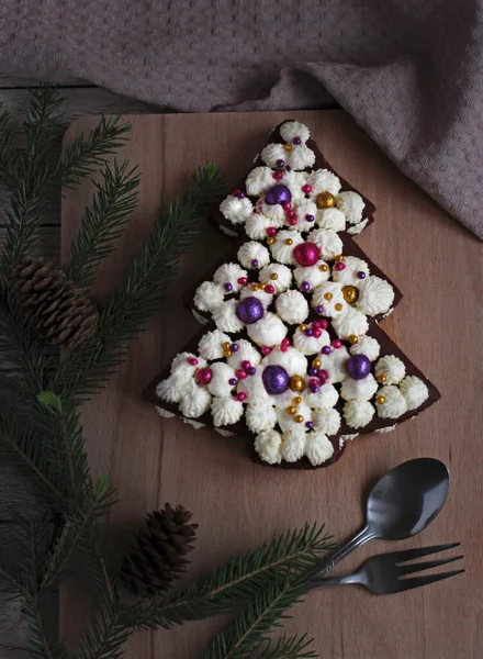Festlig vacker kaka i form av en gran på en trä bakgrund med marshmallows och gran grenar — Stockfoto