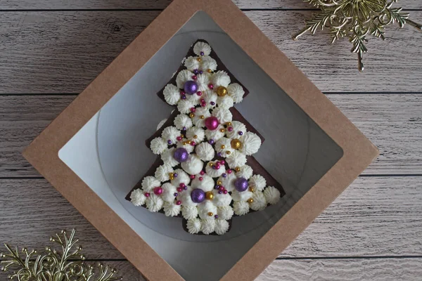 베이지 색 배경에 있는 상자 안의 가문비나무 모양의 아름다운 작은 케이크 — 스톡 사진