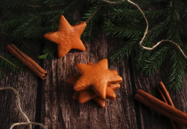 Ginger cookies in the form of stars with cinnamon and spruce branches — Stock Photo, Image