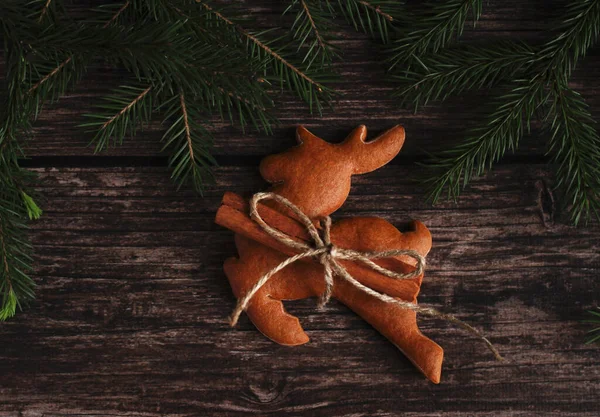 Geyik şeklinde zencefilli bisküviler. Ahşap bir arka planda tarçın ve ladin dalları.
