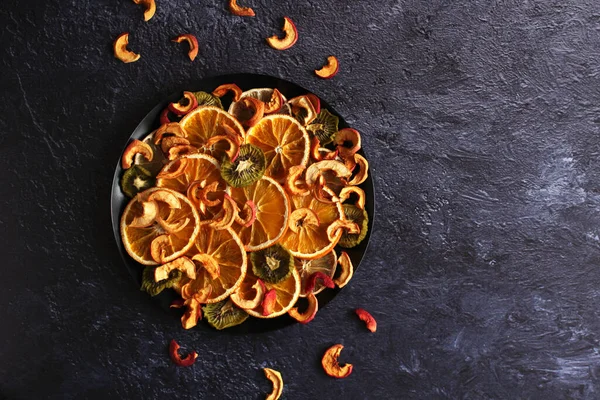 Fette secche di arancia, limone, kiwi, mele su fondo scuro — Foto Stock