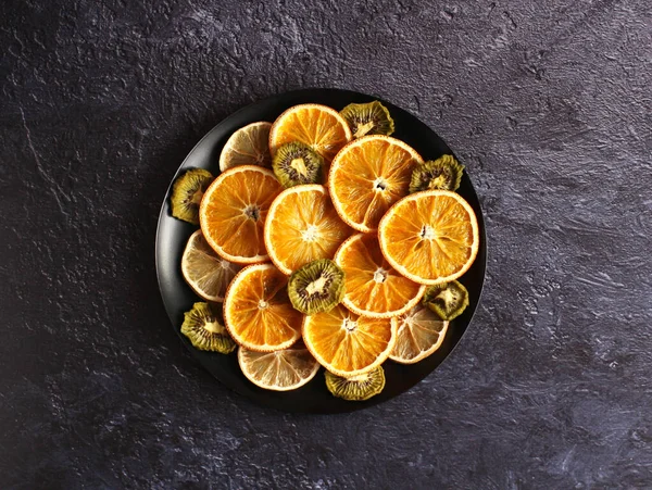 Rodajas secas de naranja, limón, kiwi sobre un fondo oscuro — Foto de Stock