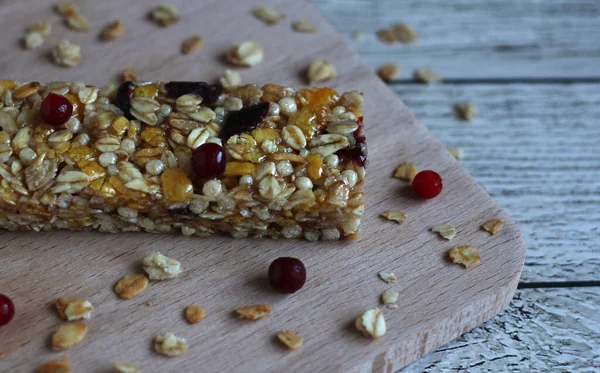 healthy cereal fitness bar with pieces of fruit and berries on a wooden background