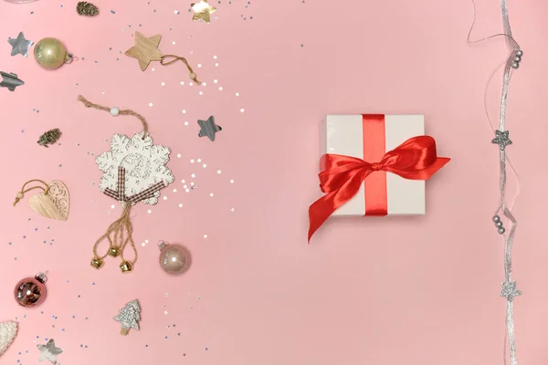Regalo de Navidad en papel de regalo blanco con lazo rojo. Fondo rosa. — Foto de Stock
