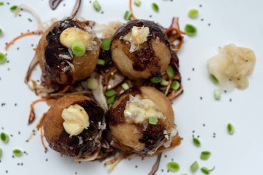 Mermer bir masanın üzerinde bir tabak takoyaki.