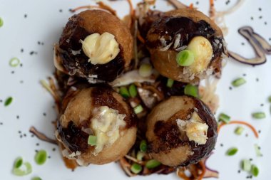 Mermer bir masanın üzerinde bir tabak takoyaki.
