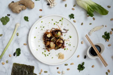 Mermer bir masanın üzerinde bir tabak takoyaki.