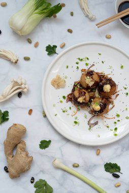 Mermer bir masanın üzerinde bir tabak takoyaki.