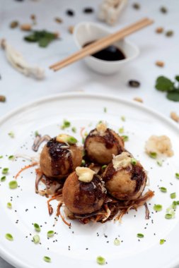 Mermer bir masanın üzerinde bir tabak takoyaki.