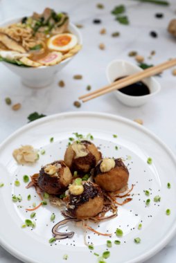 Bir kase Ramen çorbası ve bir tabak Takoyaki atıştırması. 