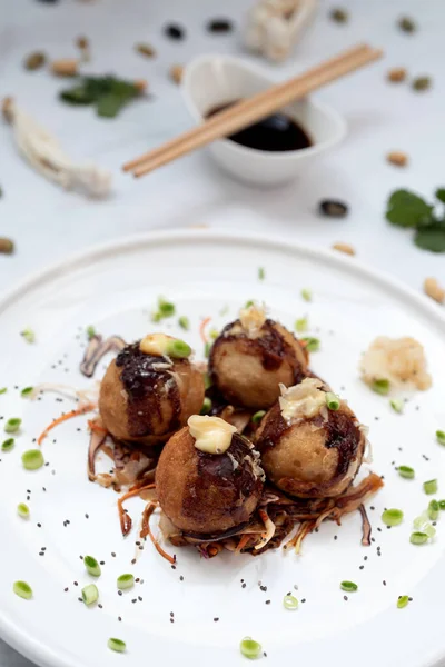 Mermer bir masanın üzerinde bir tabak takoyaki.