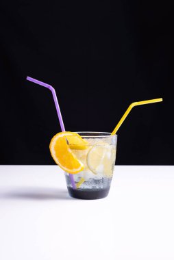 Beyaz masa ve siyah arka planda bir bardakta yaz kokteyli. minimalist kavram.