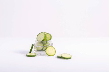 Beyaz arka planda cam bir kapta kozmetik salatalık kremi..