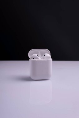Beyaz arka planda beyaz kablosuz kulaklık kutusunda.