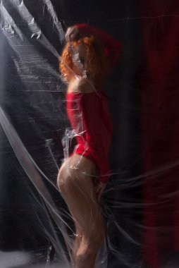 Siyah arka planda kırmızı elbiseli seksi kız sporcu..