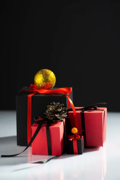 有创意的新年礼物 白桌子上红黑相间 背景漆黑 — 图库照片