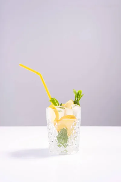 Refrescante cóctel de verano con hielo y menta, limón sobre fondo blanco —  Fotos de Stock