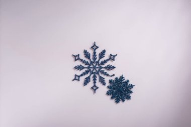 Yeni yıl minimalizmi beyaz zemin üzerinde yapay kar taneleri.