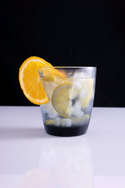 Beyaz masa ve siyah arka planda bir bardakta yaz kokteyli. minimalist kavram.