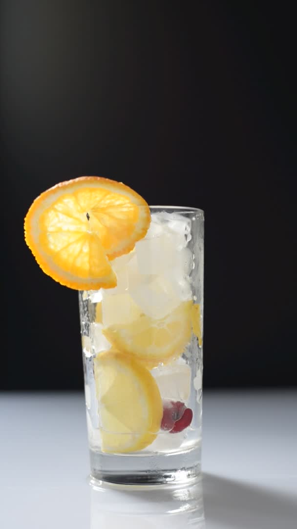 Verter Limonada Vaso Con Hielo Frutas Sobre Fondo Blanco Negro — Vídeo de stock