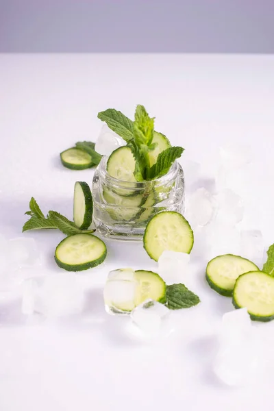 moisturizing cosmetics based on natural extracts of aloe, cucumber and ice in a glass container on a white background.