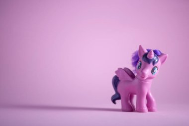 toy pink unicorn pony on a pink background.