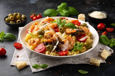 Salamura edilmiş yeşil zeytinli, kiraz domatesli ve parmesan peynirli makarna salatası. Sağlıklı yemek..