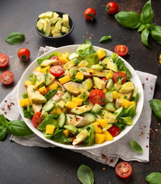 Avokado, salatalık, vişneli domatesli tavuk mango salatası. Sağlıklı yemek.