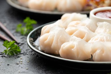 Geleneksel Asya karidesi ya da karides hakau, ha kauw ya da har gow. Lahana, havuç salatası, soya ve acı biber sosuyla servis edilir.