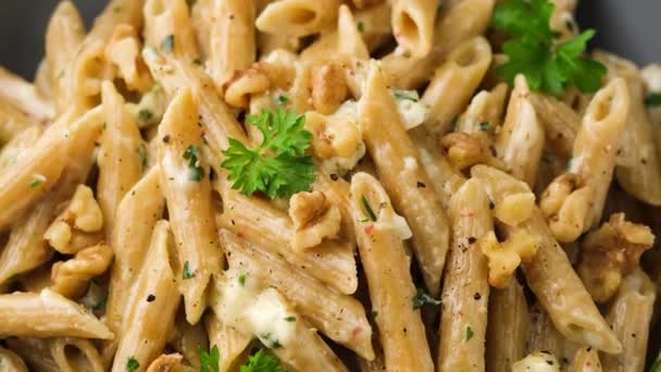 Penne pasta met gorgonzola kaas saus en walnoot. Draaiende video. — Stockvideo