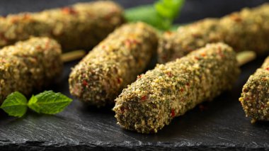 Çiğ Kofta kebabı, şiş kebap ve taşra tahtasında otların karışımı. Pişirmeye hazır