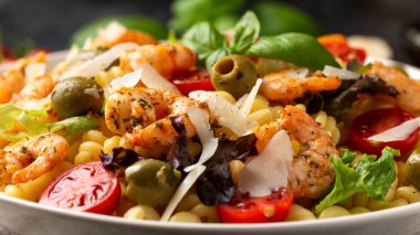 Salamura edilmiş yeşil zeytinli, kiraz domatesli ve parmesan peynirli makarna salatası. Sağlıklı yemek..