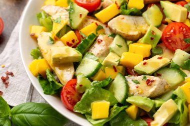 Avokado, salatalık, vişneli domatesli tavuk mango salatası. Sağlıklı yemek.