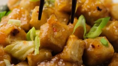 Pirinçli Tso Tofu, yeşil soğan ve yemek çubuğu kullanarak bir kaseden pak choi topluyorum. Asya Vegan Yemekleri