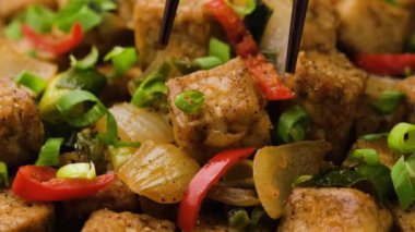 Çubukla kaseden çıtır tuzlu ve biberli soya peyniri topluyorum. Asya Vegan Yemekleri